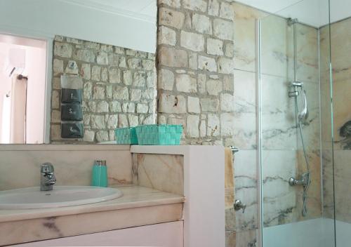 a bathroom with a sink and a glass shower at Vista Mar - Seafront Holiday Apartments in Santa Maria