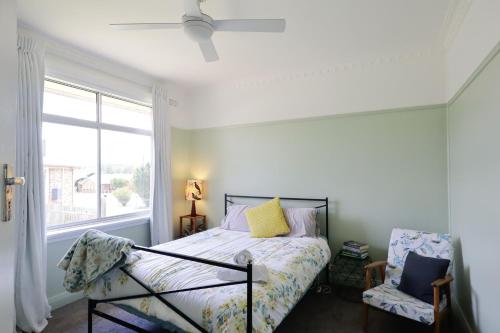 a bedroom with a bed and a window at Cosy Sun-Filled Cottage in Tenterfield