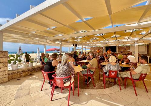 un grupo de personas sentadas en mesas en un restaurante en Vista Mar - Seafront Holiday Apartments, en Santa Maria