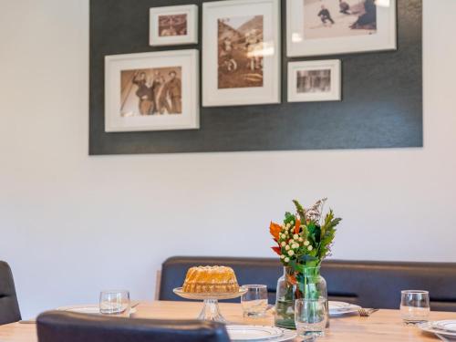 a table with a cake and a vase of flowers at Roßbrand-Blick in Untertauern