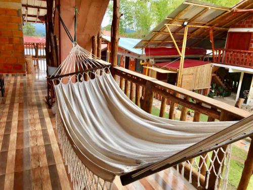 a hammock hanging from a porch of a house at Hotel Cabañas y Glamping Colinas De San Diego in San Agustín