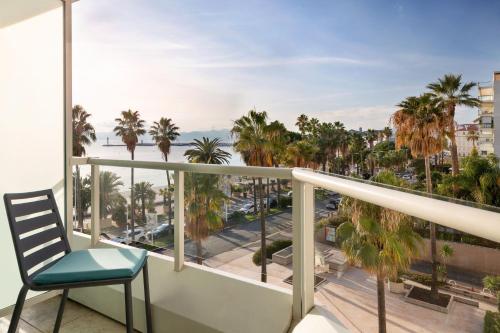 a balcony with a chair and a view of the ocean at JW Marriott Cannes in Cannes