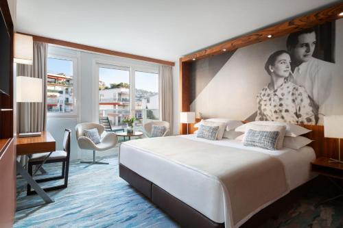 a hotel room with a large bed and a large window at JW Marriott Cannes in Cannes