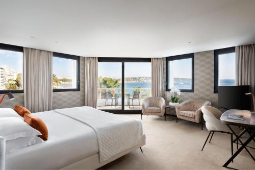 a hotel room with a bed and a desk and chairs at JW Marriott Cannes in Cannes