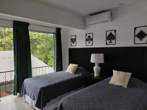 福尔图纳CR Arenal Apartments Familiar的带阳台的卧室内的两张床