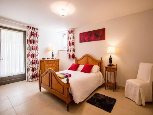 a bedroom with a bed with red pillows at Gite La Sempesserre in Monjoi