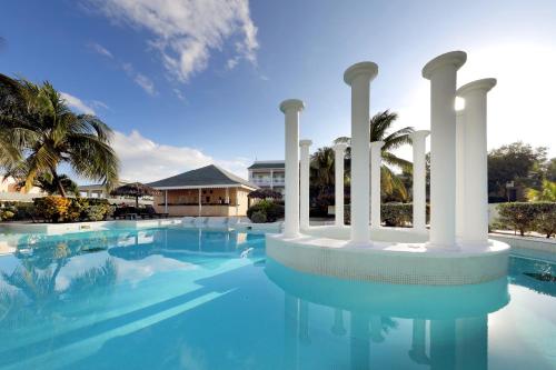 a swimming pool with columns and a building at Grand Palladium Jamaica Resort & Spa All Inclusive in Lucea