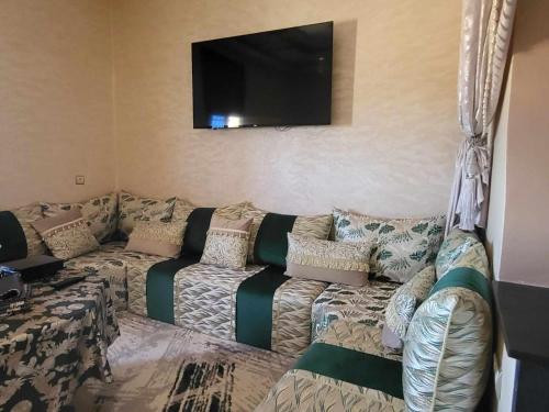 a living room with a couch and a flat screen tv at شقق مفروشة ريحانة حي تيرت كلميم in Guelmim