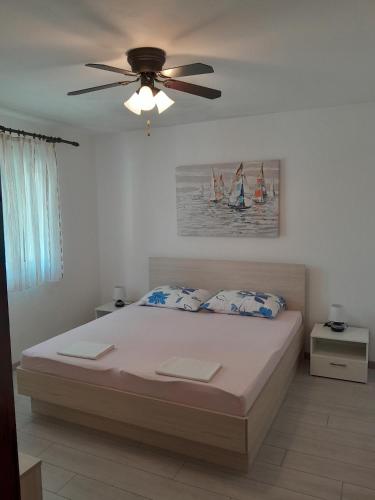 a bedroom with a bed with a ceiling fan at Apartments by the sea Mudri Dolac, Hvar - 4042 in Vrbanj