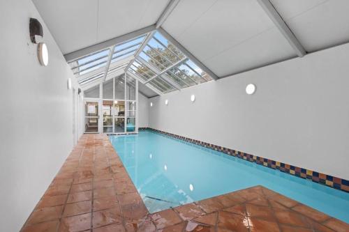 an indoor swimming pool with a glass ceiling at Warm and inviting - Free carpark in Christchurch