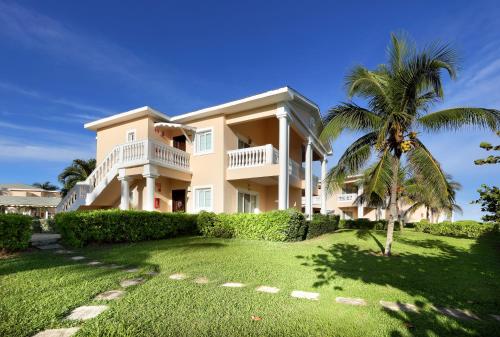 a large house with a palm tree in front of it at Grand Palladium Jamaica Resort & Spa All Inclusive in Lucea