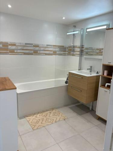 une salle de bain avec une baignoire et un lavabo dans l'établissement Charmant appartement cosy, à Arcueil
