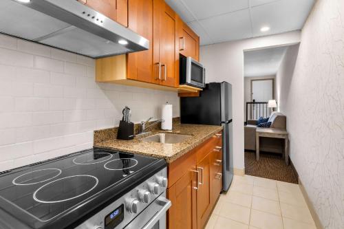 a kitchen with a stove and a sink and a refrigerator at Best Western Halton Hills in Georgetown
