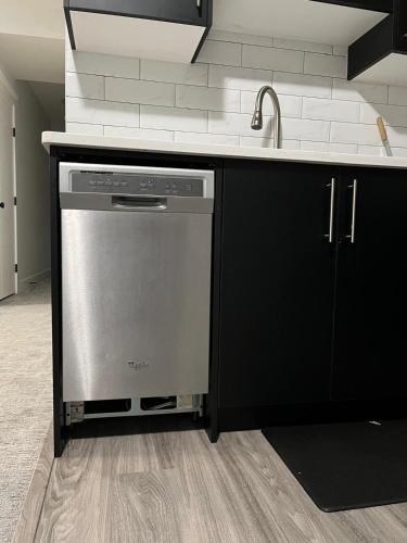 a kitchen with a dishwasher and a sink at Arriva Homestay in Calgary