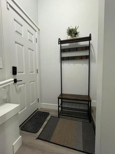 a hallway with a door with a shelf and a rug at Arriva Homestay in Calgary