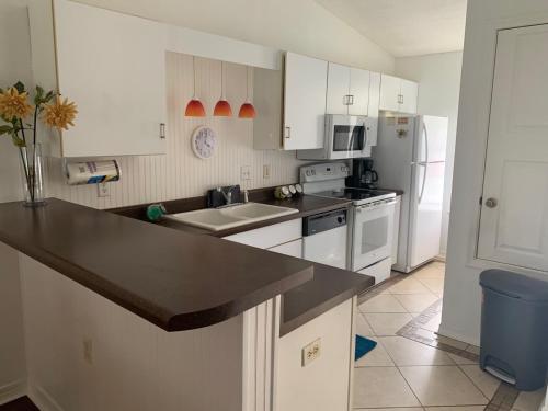 a kitchen with white cabinets and a black counter top at Charming 2 bdr 1 bath home fenced byard N Pensacola Pet Friendly Close to bases in Pensacola