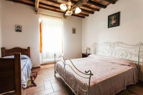 a bedroom with a large bed and a window at Villa Il Corniolo in Morra
