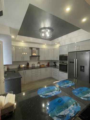 a kitchen with white cabinets and blue mats on the floor at Irene s Home in Lourinhã