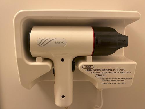 a hair dryer in a holder in a wall at Summit Views Hakuba in Hakuba