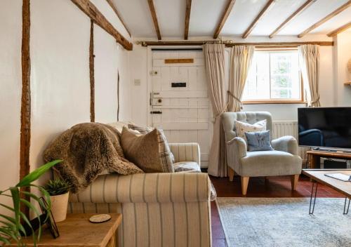 a living room with a couch and a chair at Poppy Cottage - Cosy 2 Bedroom, Perfect for Family! in Shottery