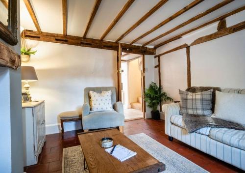 a living room with a couch and a table at Poppy Cottage - Cosy 2 Bedroom, Perfect for Family! in Shottery