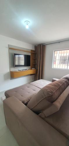 une chambre avec un grand lit et une télévision dans l'établissement IMPERDÍVEL APARTAMENTO em frente ao BURITI SHOPPING, à Aparecida de Goiânia