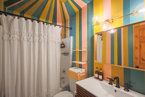 a bathroom with a striped shower curtain and a toilet at Sessions Retreat & Hotel in Big Bear Lake