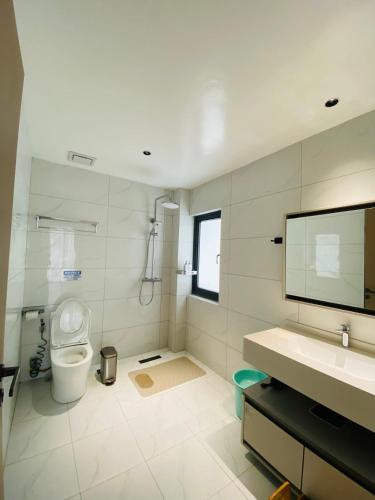 a white bathroom with a toilet and a sink at Willander Resort in Panglao Island