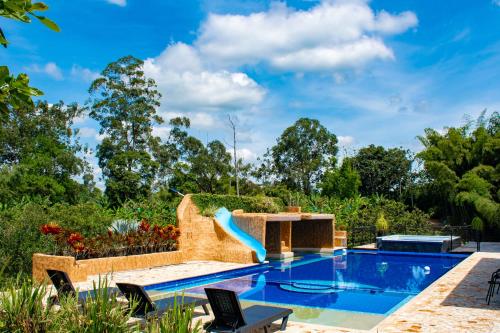 a swimming pool with a slide in the middle at Paraíso familiar en el corazón del eje cafetero in La Tebaida