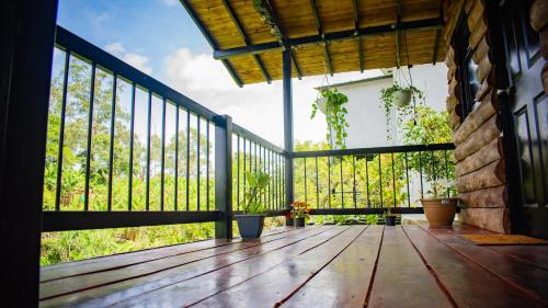 a porch with a wooden deck with a fence at Paraíso familiar en el corazón del eje cafetero in La Tebaida