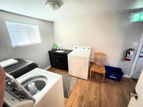 a laundry room with a washing machine and a washer at James house J&J Chilliwack in Chilliwack