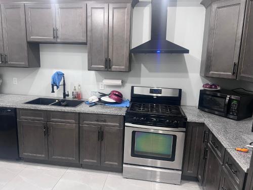Una cocina con gabinetes de madera y un horno de estufa. en Be-3 Private Room In Cambridge, en Cambridge