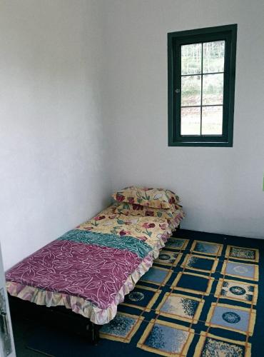 a bed sitting in a room with a window at Princess Villa in Pasirjambu