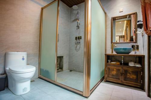 a bathroom with a shower and a toilet and a sink at Pingyao Grand Theater Guild Hall East Garden in Pingyao