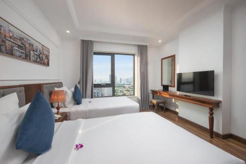 a hotel room with two beds and a television at The Sail Hotel - My Khe Beach in Da Nang