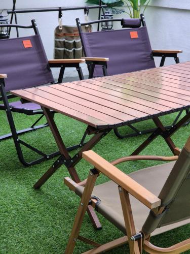 a wooden picnic table and two chairs on grass at Soban Stay in Busan