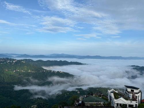 a view of a mountain with clouds in the valley at The Local Guest House in Āīzawl