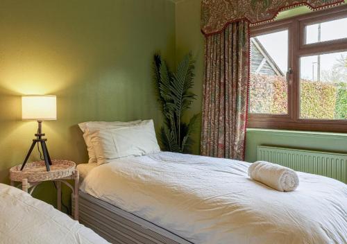 a bedroom with a bed with a window and a bed sidx sidx sidx at Charming 3BD Cotswolds Family Retreat in Bourton on the Water