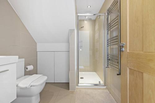 a bathroom with a toilet and a glass shower at Stylish 1-Bed Flat in Prime Kensington Location in London