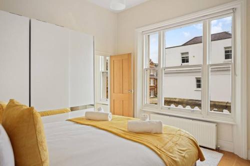 a bedroom with a bed and a large window at Stylish 1-Bed Flat in Prime Kensington Location in London