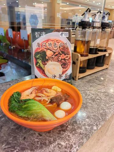 an orange bowl of soup with broccoli on a counter at Holiday Inn Express Xiamen Lushan -Shopping Center by IHG in Xiamen