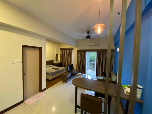 a living room with a table and a bedroom at Junikastay BLagoon Melaka in Melaka