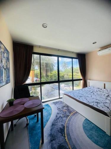 a bedroom with a bed and a desk and a window at Lux apartments TOP in Koh Samui