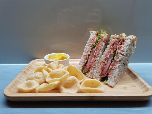 a sandwich and chips on a plate with a sandwich and dipping sauce at MySpace Hotel Comembo Taguig in Manila
