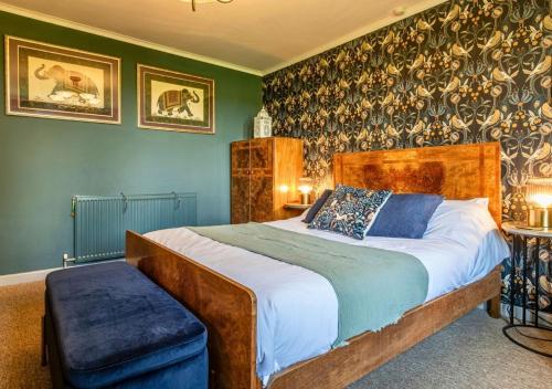 a bedroom with a large bed with green walls at Gorgeous Rural 4 Bed Farm Cottage - With Hot Tub! in Norton Saint Philip