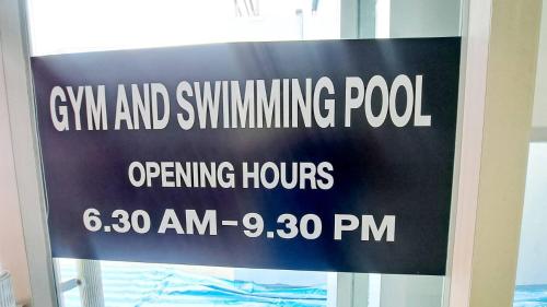 a sign on the door of a gym and swimming pool opening hours at 6C-Short-term rental allowed-2BRs Downtown Bangkok in Makkasan