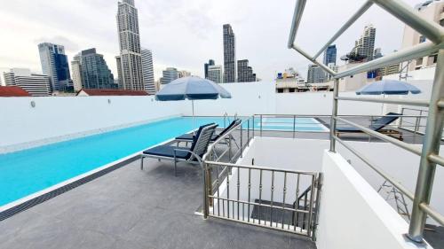 a swimming pool with chairs and umbrellas on top of a building at 6C-Short-term rental allowed-2BRs Downtown Bangkok in Makkasan