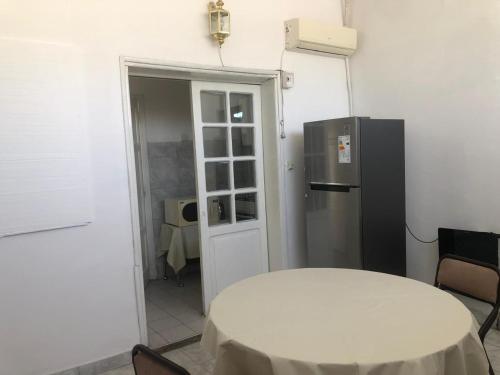 a kitchen with a white table and a refrigerator at El Solaz en la Ciudad in San Juan