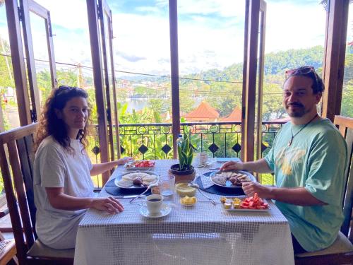 a man and a woman sitting at a table with food at Sesatha lake Kandy in Kandy