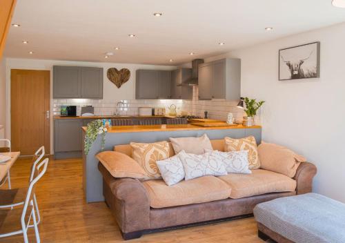 a living room with a couch and a kitchen at Discovery Barn - Luxury 2 Bed Barn Conversion! in Cropthorne